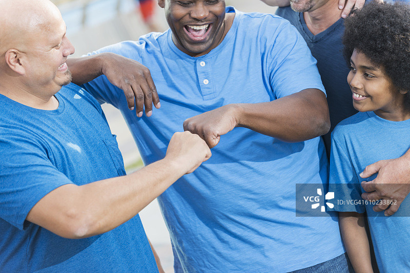 一群身穿蓝色衬衫的男人互相击拳庆祝图片素材