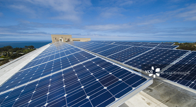 安装在商业建筑屋顶上，有助于降低能源成本的太阳能电池板阵列图片素材