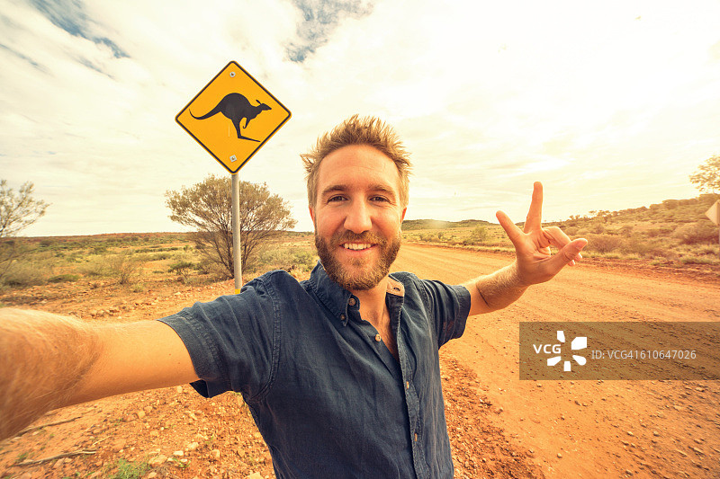 在澳大利亚袋鼠标志附近的青年男子自拍照图片素材