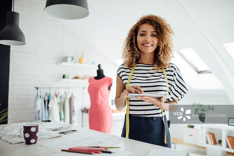 在她的工作室里使用数位平板电脑的拉丁裔裁缝图片素材