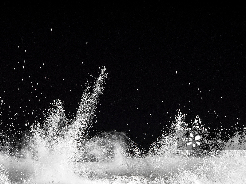 黑色背景上的白色粉末爆炸颗粒图片素材