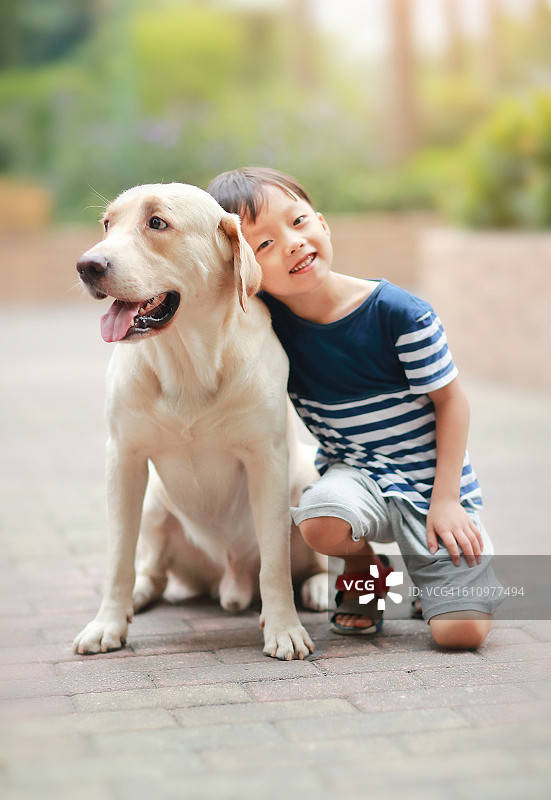 抱着拉布拉多犬的小男孩图片素材