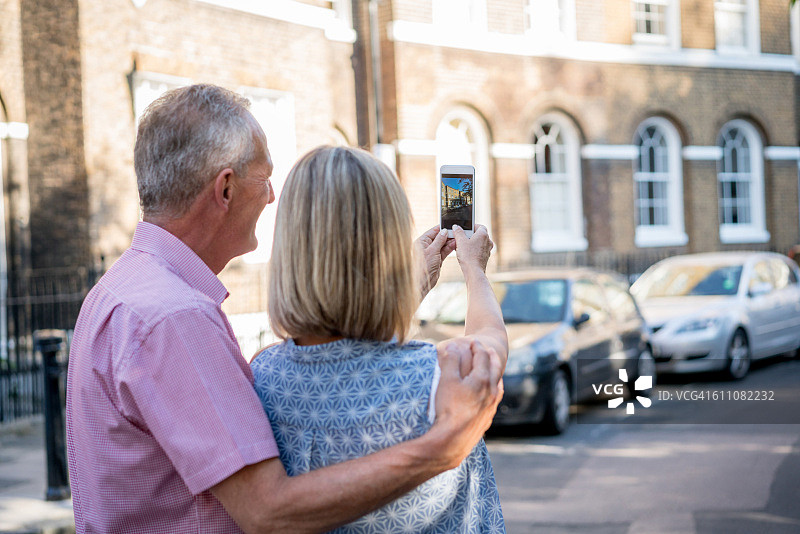 情侣在找房子并拍照图片素材