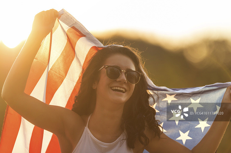 戴太阳镜并举着美国国旗的少女图片素材