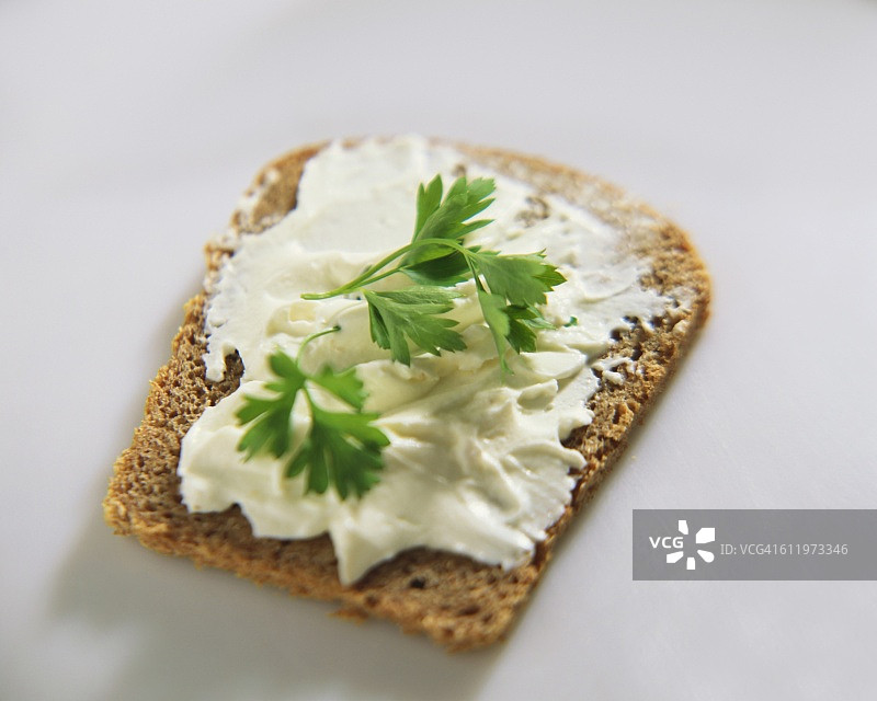 全麦面包上的软奶酪和欧芹图片素材