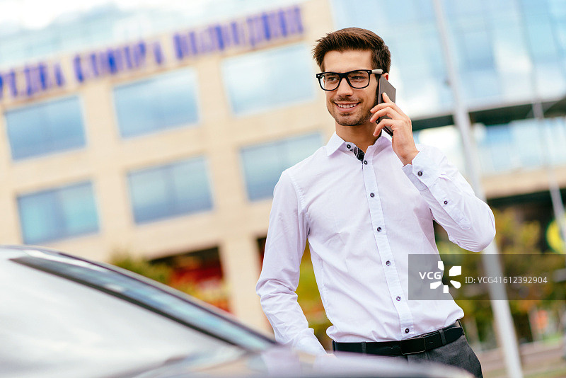 快乐的商人从豪华轿车里出来图片素材