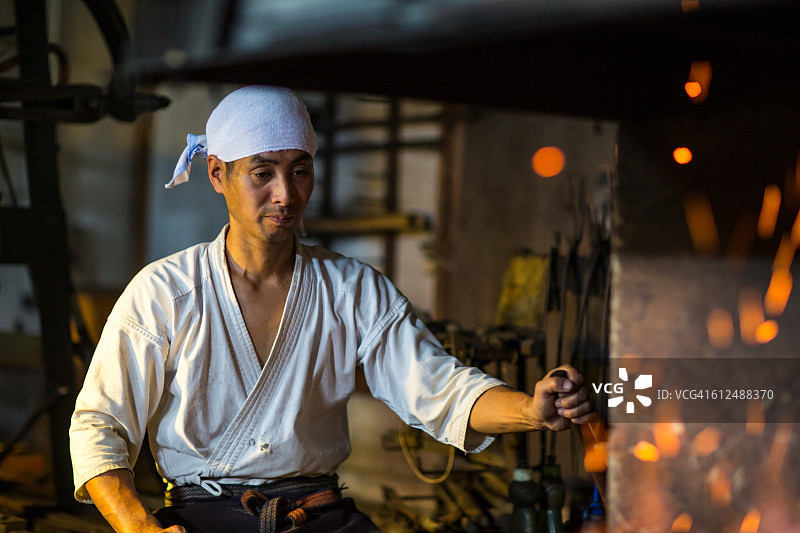 日本铁匠拨火准备锻造剑图片素材