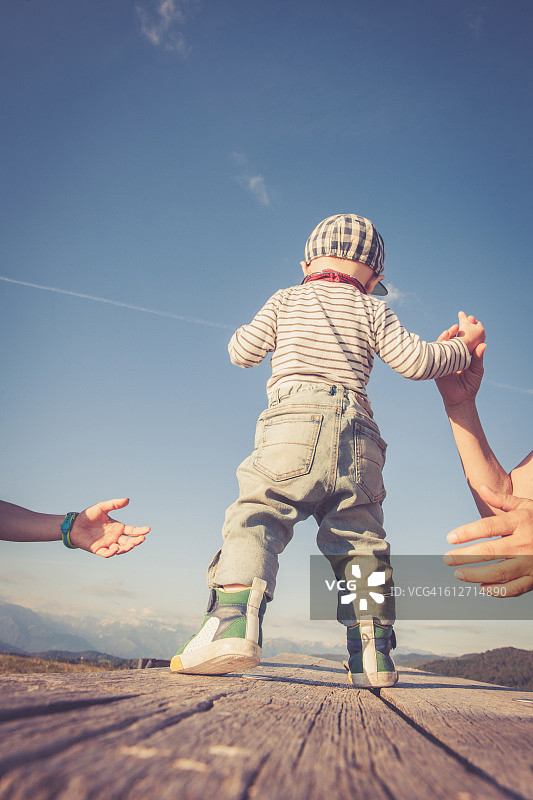 在父母的帮助下，宝宝迈出人生的第一步图片素材