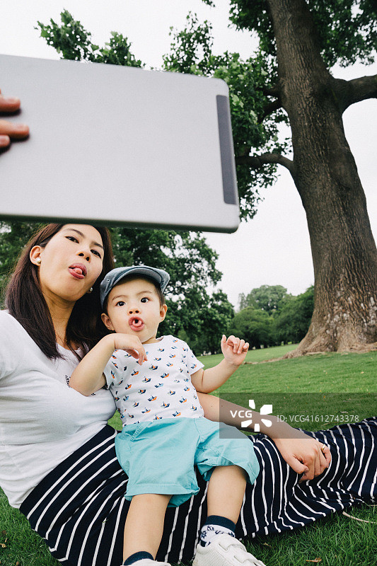 母子在户外用平板电脑自拍图片素材