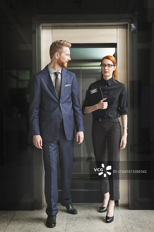 商务人士在电梯附近交谈图片素材