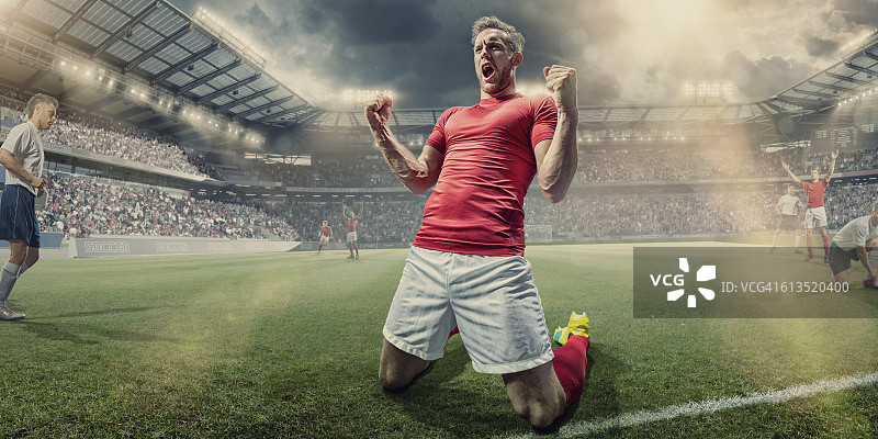足球运动员跪在球场上庆祝图片素材