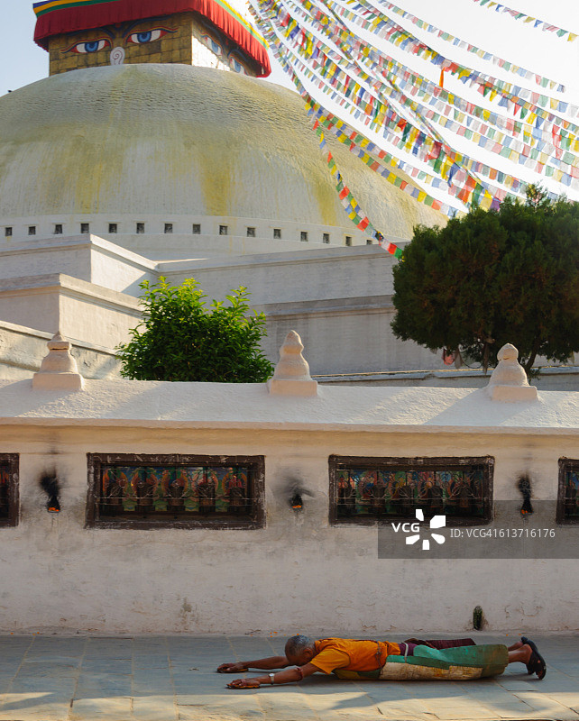 在尼泊尔加德满都的博达哈大佛塔，信徒行五体投地礼图片素材