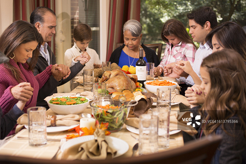 一家人在奶奶家感恩节晚餐前祈祷图片素材