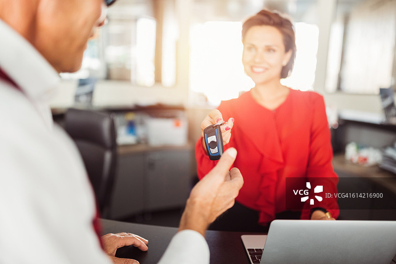 汽车经销商将车钥匙交给客户图片素材