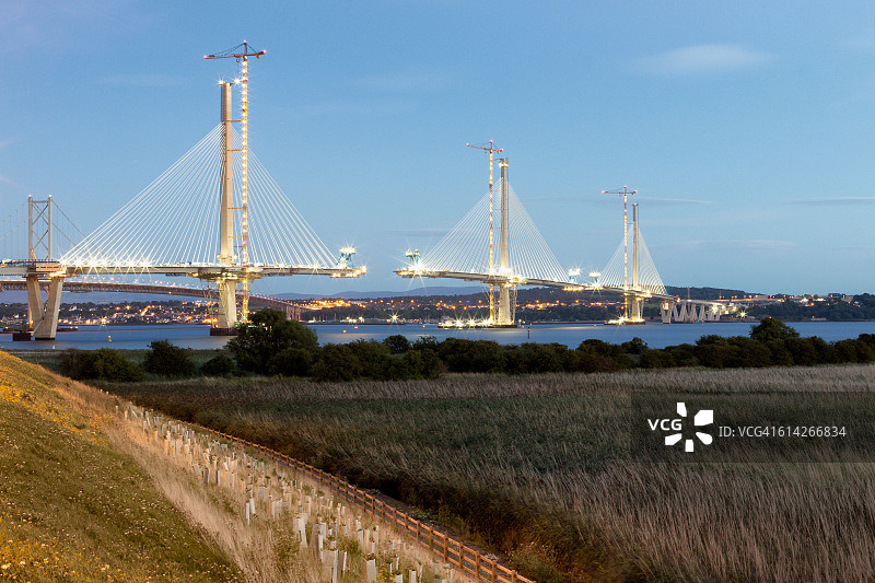夜间照明的在建桥梁和建筑起重机图片素材