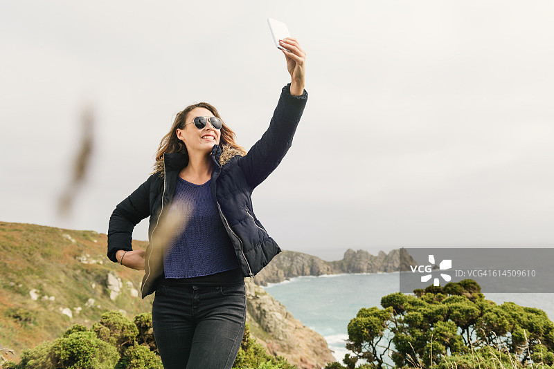 在康沃尔海岸自拍的年轻女人图片素材