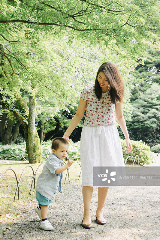 快乐的母子在公园户外散步图片素材