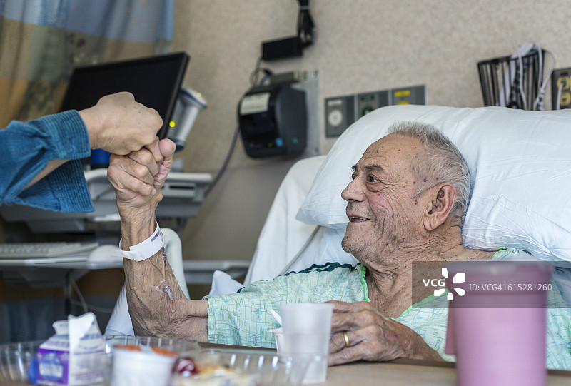 年长的男人在医院里与家人碰拳图片素材