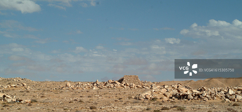 非洲，北非，撒哈拉沙漠，摩洛哥占领下的西撒哈拉，远处有古代石 building 的岩石景观图片素材
