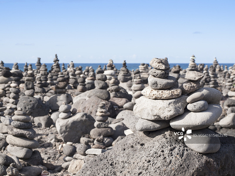 海滩上堆叠的石头细节，以天空为背景图片素材