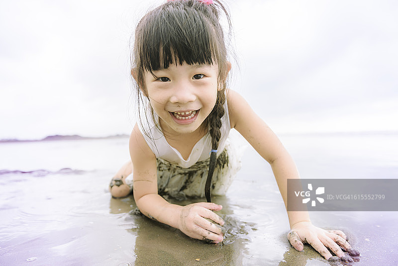 儿童在沙滩上开心地躺着图片素材