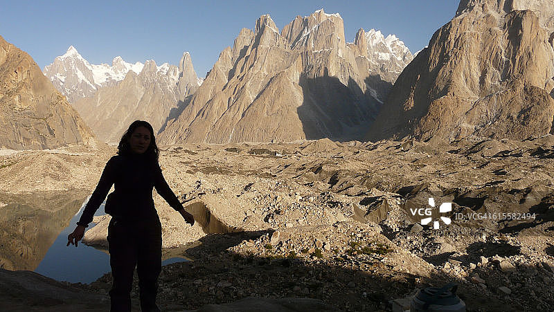 女徒步者在巴尔托洛冰川，背景是特兰戈塔和敦莫大教堂。喀喇昆仑山脉，巴基斯坦图片素材