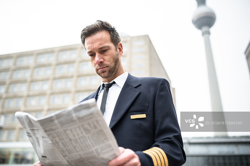 身穿飞行员制服阅读报纸的商人图片素材