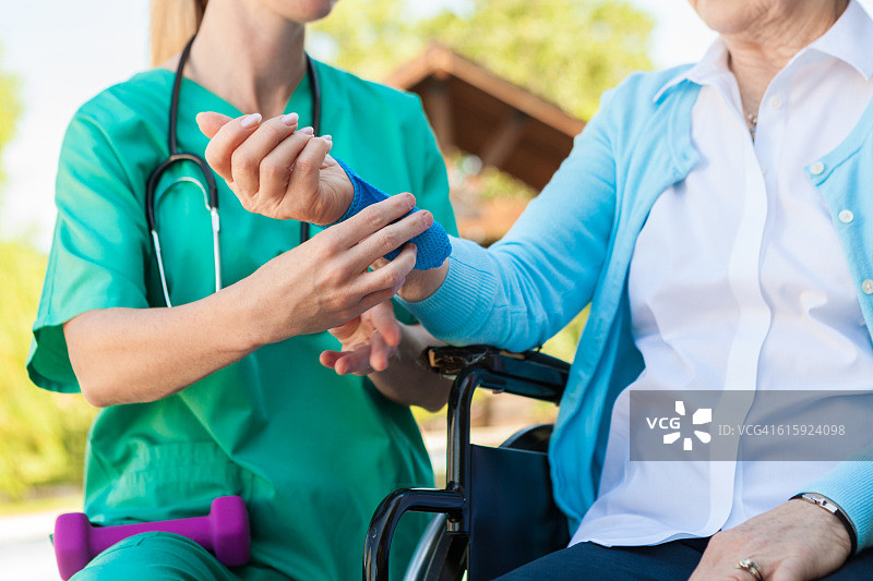 护士帮助坐在轮椅上的受伤老年妇女图片素材