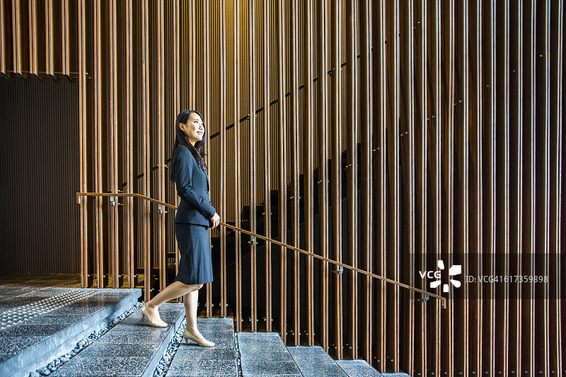 在办公室大厅楼梯上行走的日本女商人图片素材