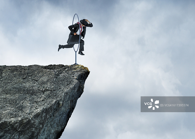 商人跳过悬崖边缘的障碍图片素材