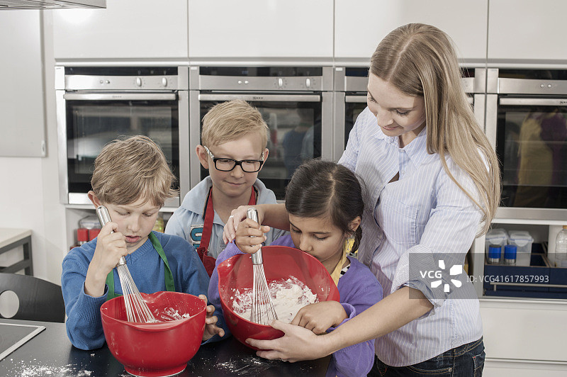 德国巴伐利亚：家政课上老师和学生用搅拌器打奶油图片素材