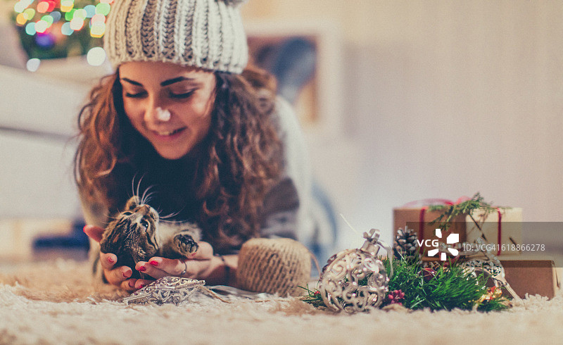 年轻女子和小猫在圣诞节前夕图片素材