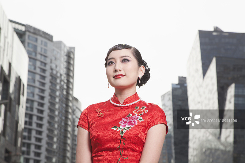 身穿旗袍的中国女人在城市中心图片素材