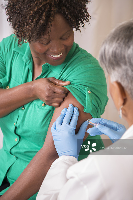 医生或护士在诊所为患者接种流感疫苗图片素材