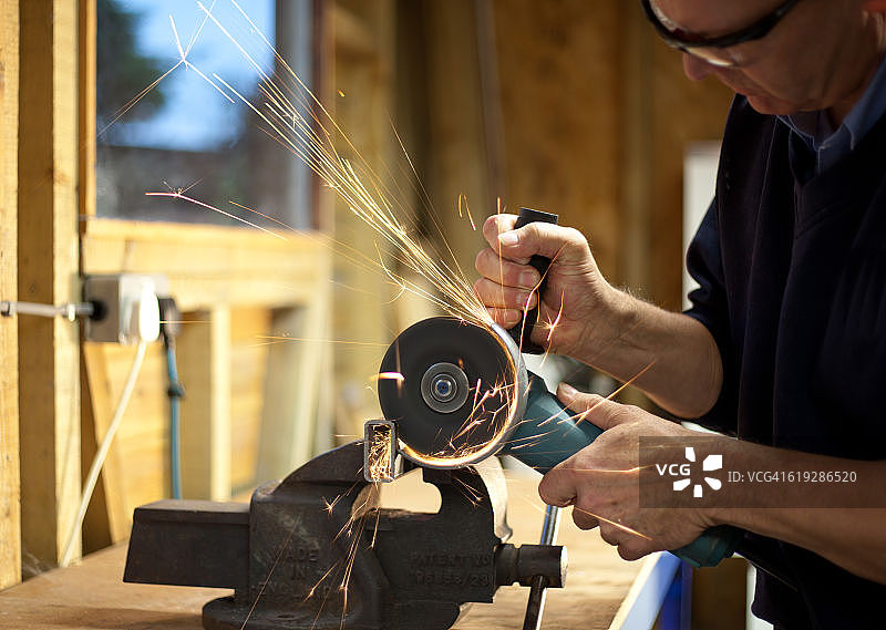 男子使用角磨机切割金属图片素材