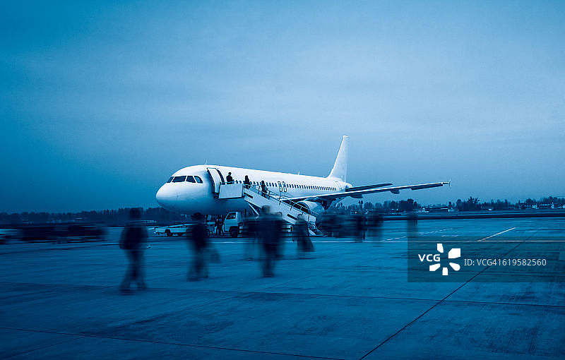 人们在跑道上登上飞机图片素材