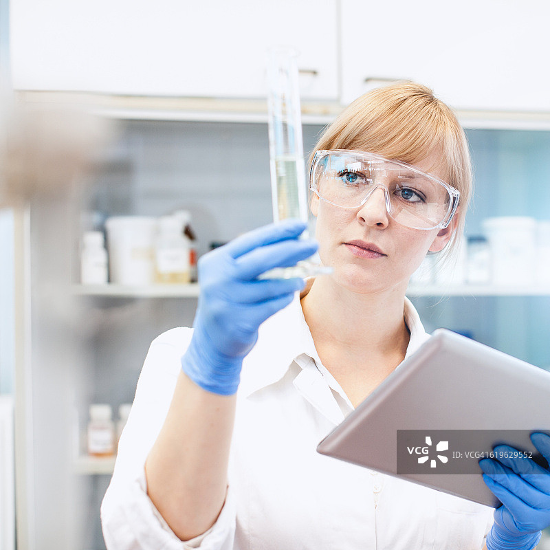 科学家观察量筒，手持平板电脑图片素材