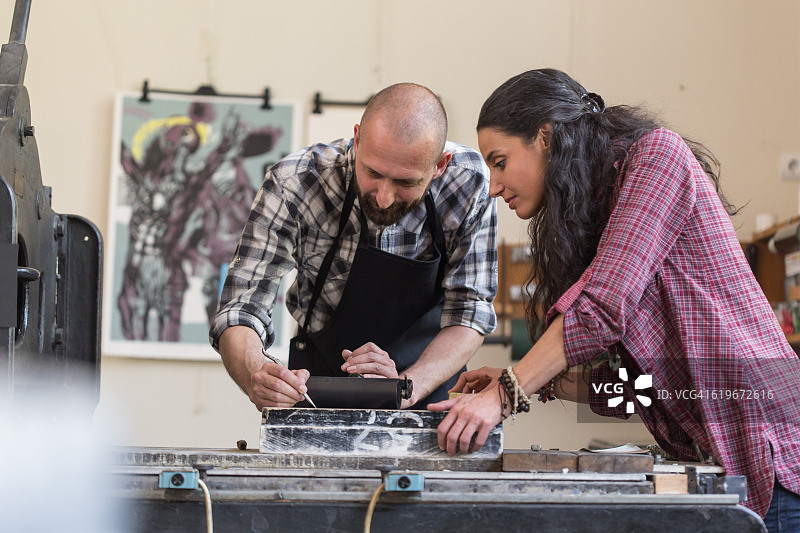 情侣在工作室用印刷机制作石版画图片素材