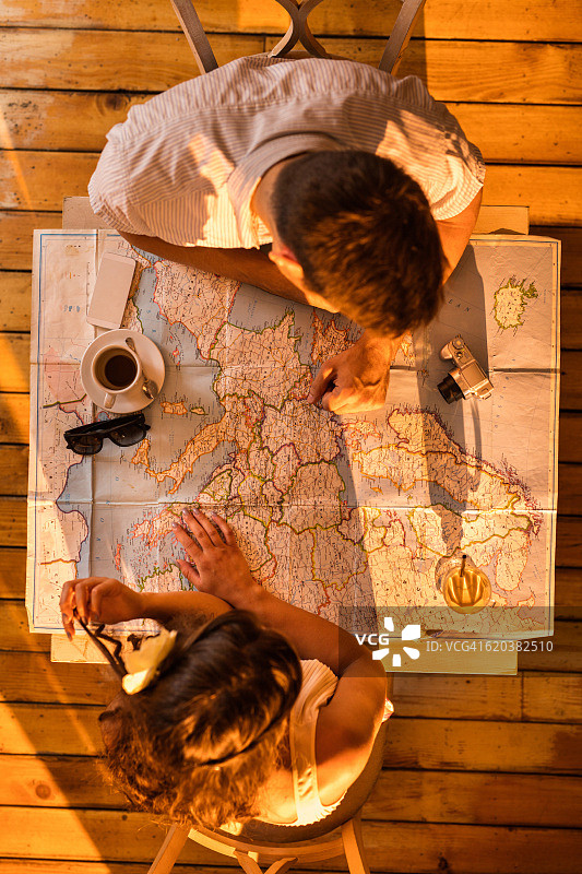 情侣在地图上查找旅行目的地（俯视）图片素材