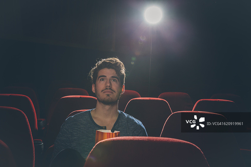 在电影院看电影的年轻男人图片素材