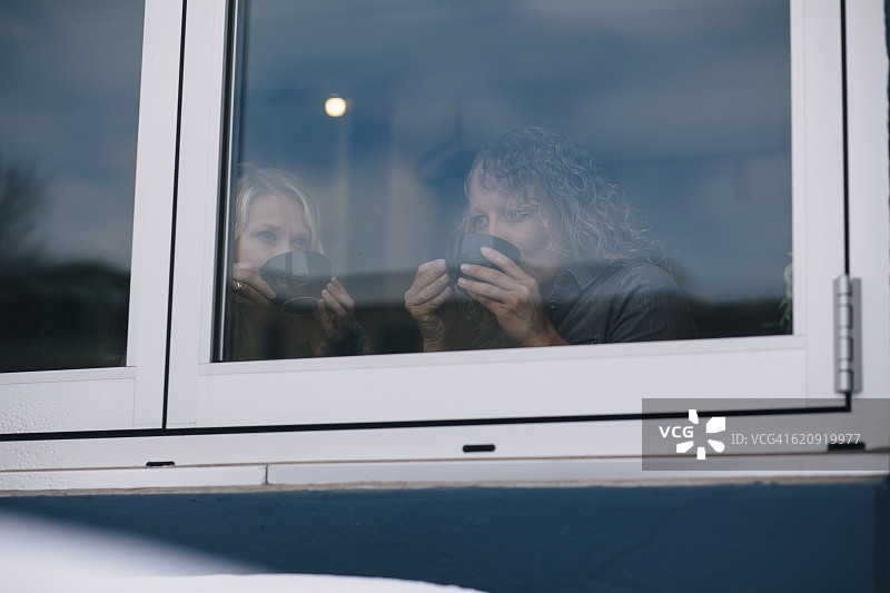 咖啡店橱窗里的两个中年女性朋友图片素材