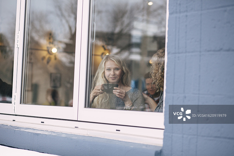 两位中年女性朋友在咖啡店看手机图片素材