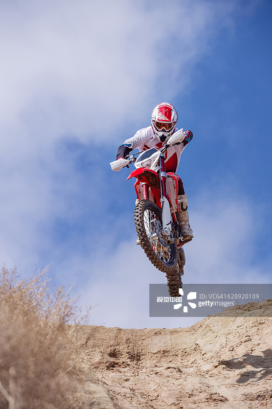 在山坡上骑越野摩托车的摩托车手图片素材