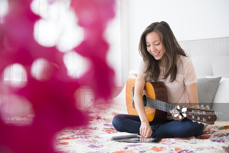 混血女人在床上弹吉他图片素材