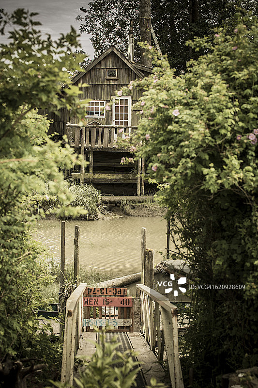 加拿大不列颠哥伦比亚省芬恩湿地菲沙河上的码头和孤独的木屋图片素材