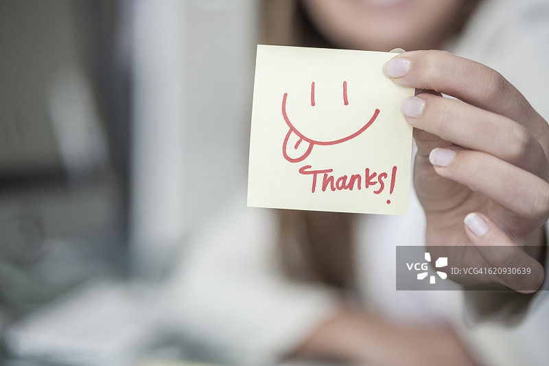 女人拿着带有笑脸便签的特写镜头图片素材