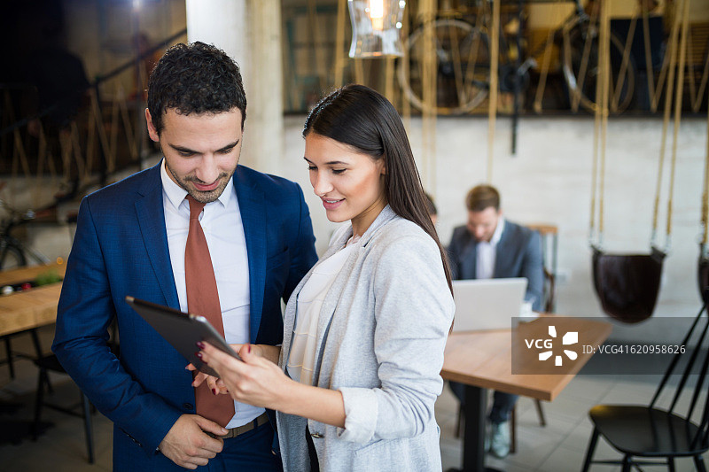 年轻商人使用平板电脑讨论业务战略图片素材