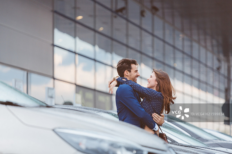 情侣在机场停车场拥抱图片素材
