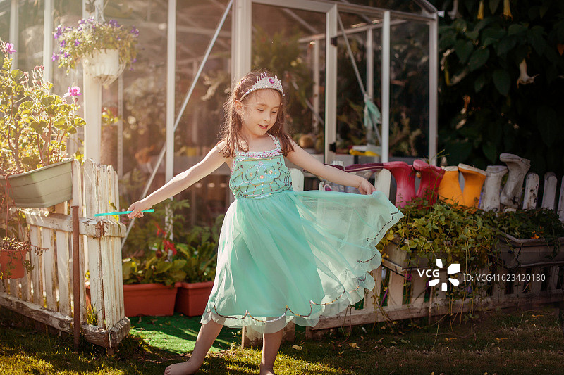 在田野里穿着公主裙跳舞的女孩（5岁）图片素材