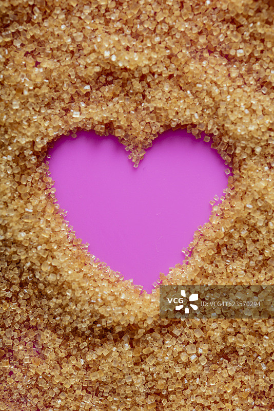 由红糖晶体制成的粉色爱心特写图片素材